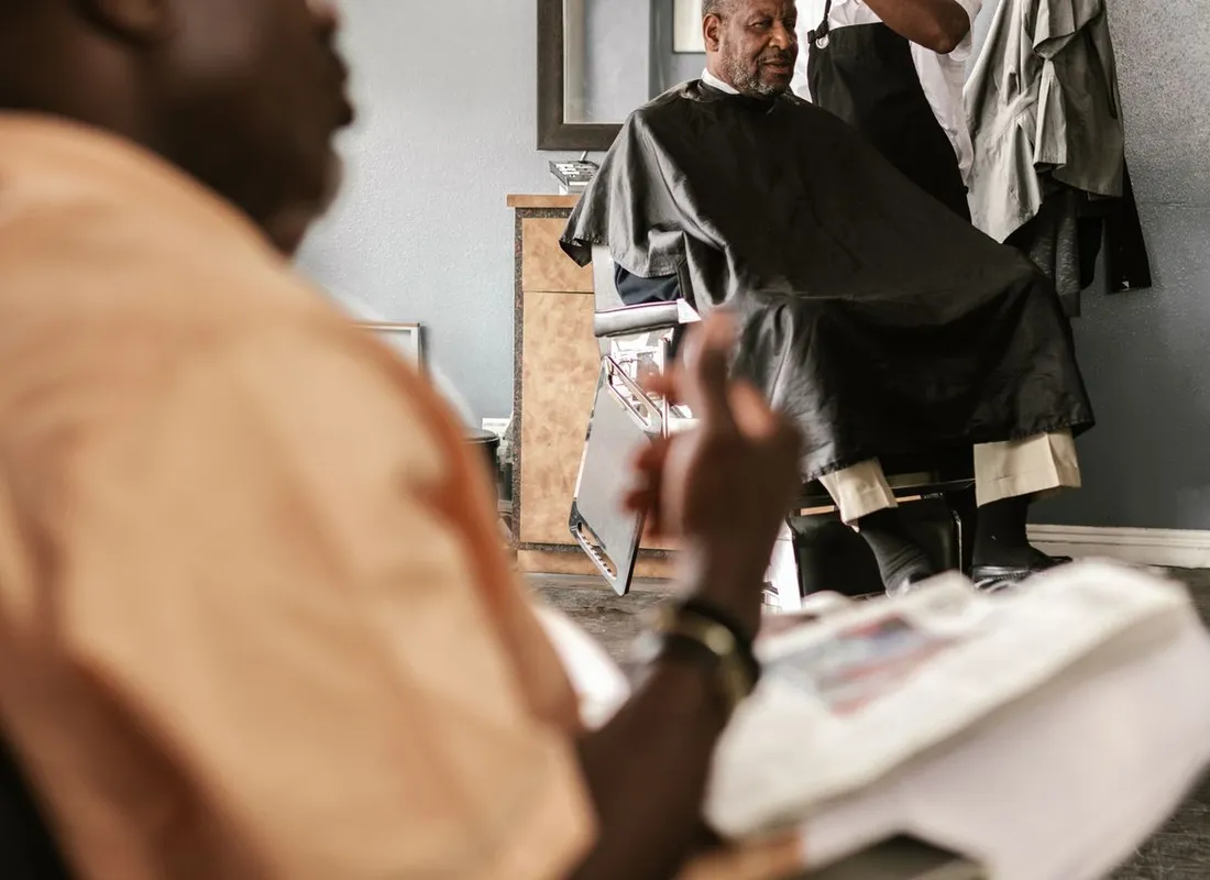 Barber shaping a client's hair in a welcoming shop