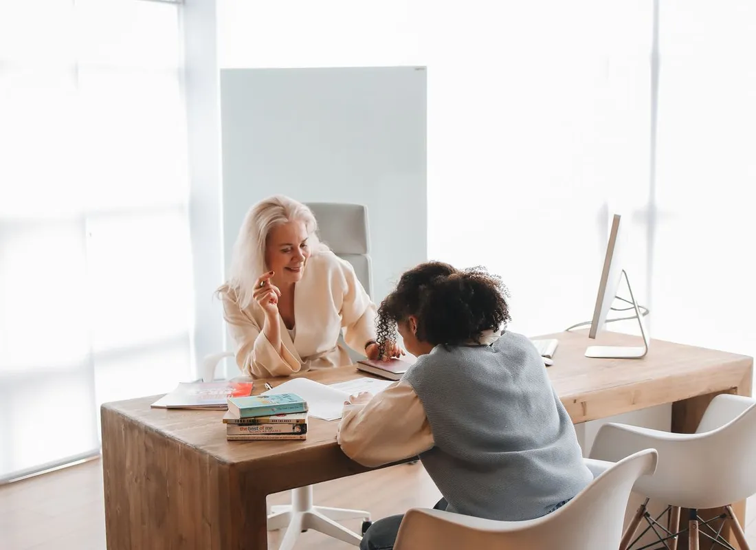 Tutor and student working together at a bright desk